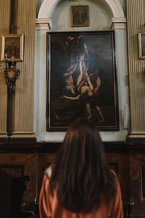 Painting in Church behind Brunette Woman