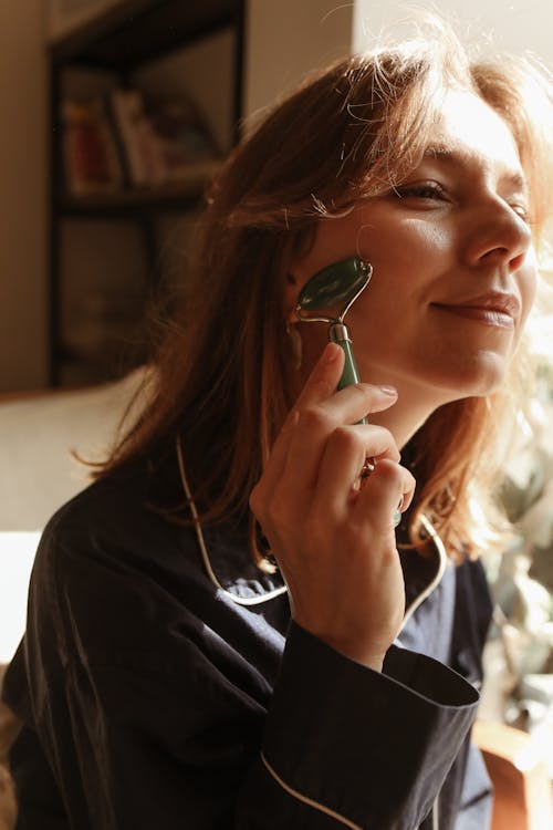 A Woman using a Jade Roller
