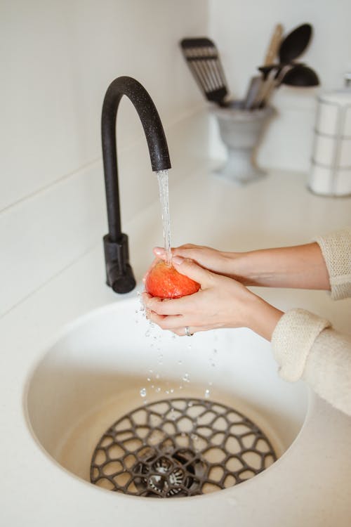 Close-up of Woman Washing an Apple in a Sink 