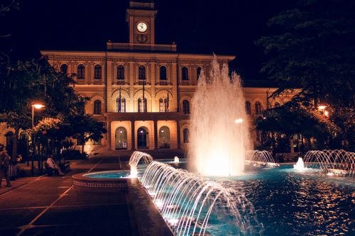 Free A stunning nighttime scene of an illuminated fountain and architectural facade in Ohlstadt, Germany. Stock Photo