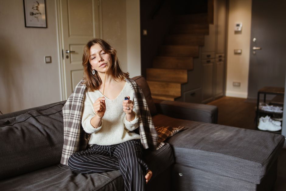 Woman sitting cozy on a couch indoors, exuding a relaxed lifestyle vibe. Woman sitting cozy on a couch indoors, exuding a relaxed lifestyle vibe.