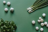 White and Green Round Fruits on Green Textile