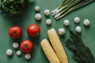Corn and Red Tomato on Green Table