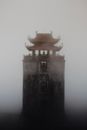 Tall Buddhist pagoda in dense fog