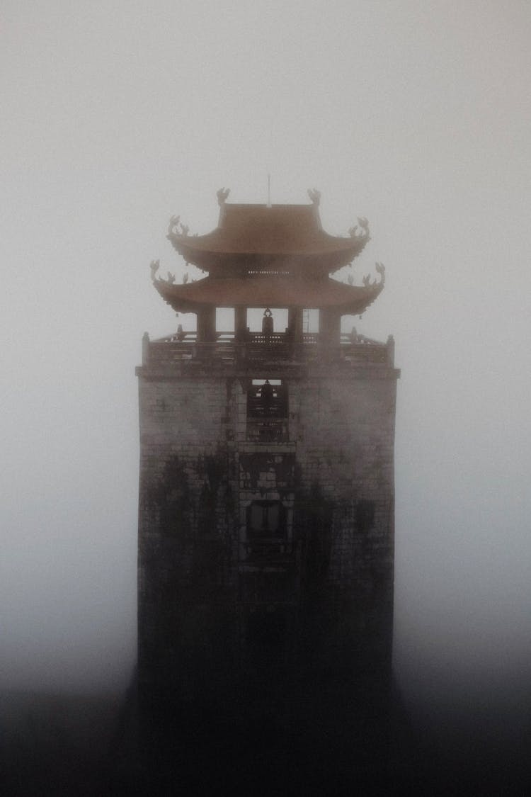 Tall Buddhist Pagoda In Dense Fog