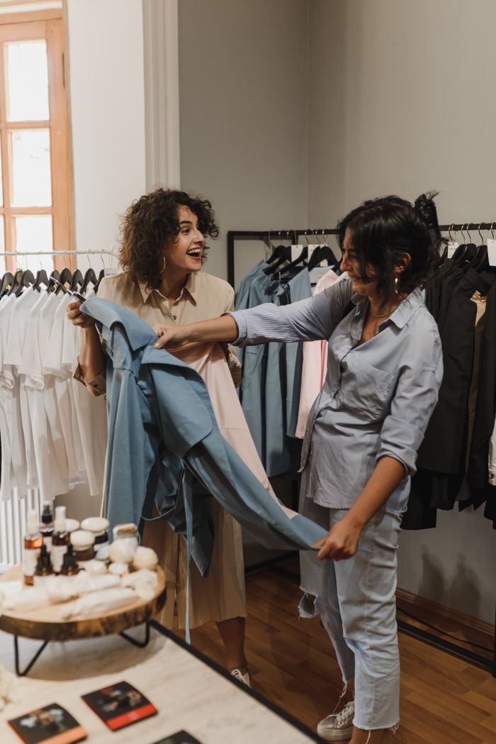 Two shoppers browsing rails in a boutique — photo by Arina Krasnikova on Pexels