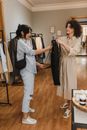 女士们在精品店试穿衣服，面带微笑地享受购物体验