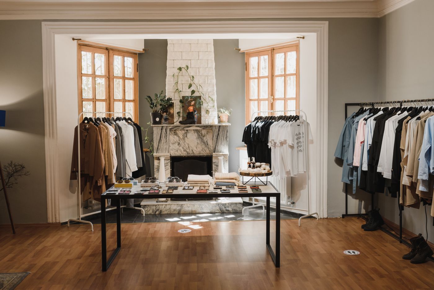 Intérieur de la boutique OMBRA de Madrid avec cheminée en marbre et portants
