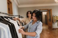 两位女士在一家优雅的精品店里一起浏览衣架