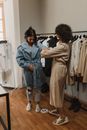 两名女子正在精品店里试穿衣服，时尚购物