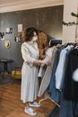 一名女子戴着口罩在商店里浏览衣服
