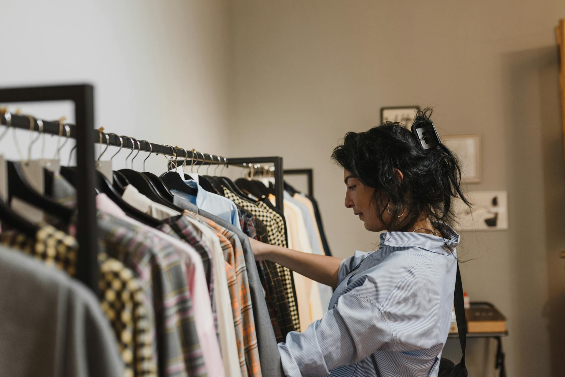 A woman exploring clothing options in a stylish boutique store setting.