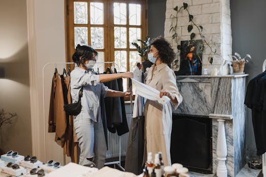 Two women wearing masks shopping in a boutique during the COVID-19 pandemic.