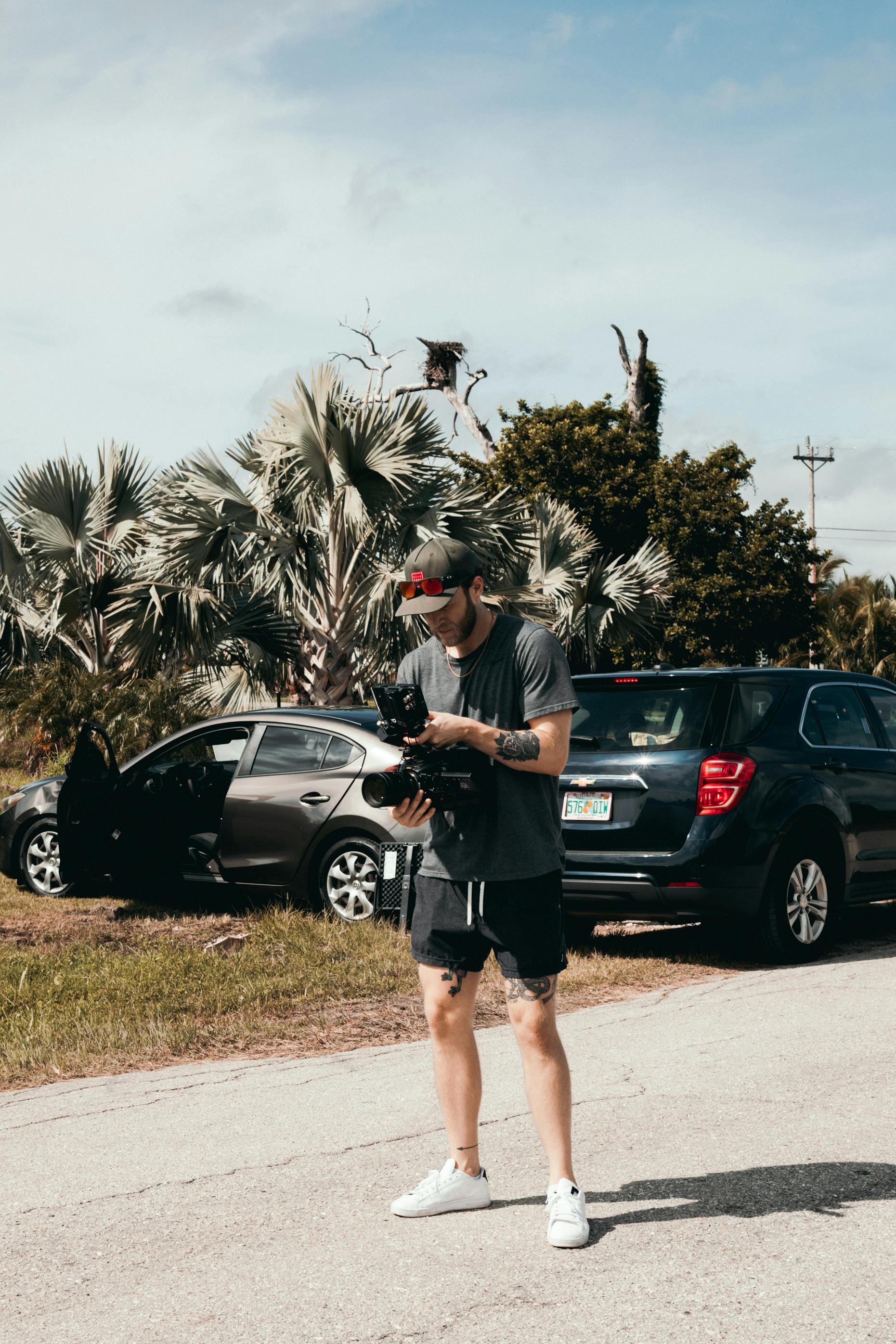 Photography of Man Holding Dslr Camera · Free Stock Photo