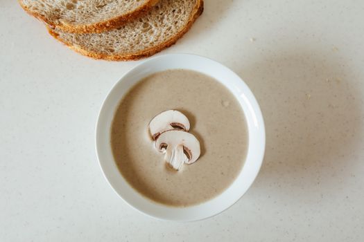 Delicious bowl of creamy mushroom soup served with sliced bread, perfect for a wholesome meal.