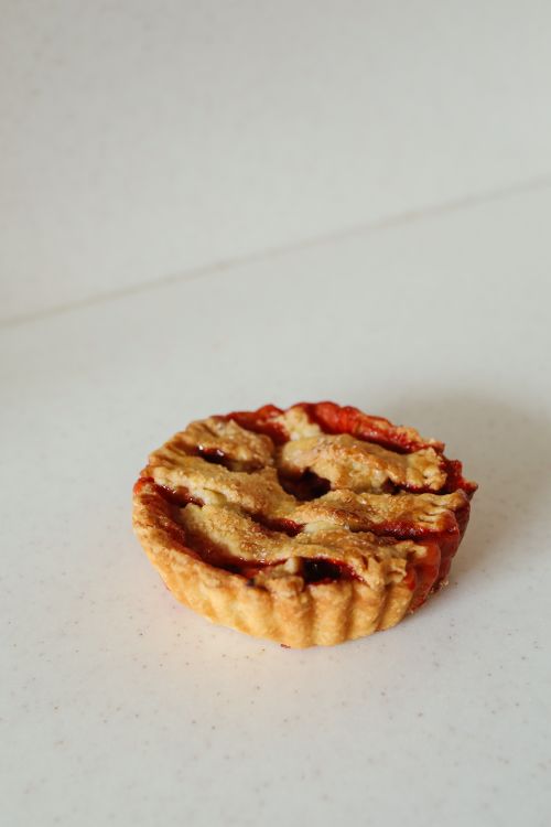 Free A golden-brown cherry pie set against a clean marble backdrop, perfect for food photography. Stock Photo