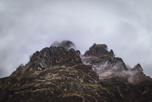 Free A stunning view of jagged Andes peaks surrounded by thick, moody clouds. Stock Photo