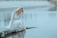 Calm woman squatting down and touching water