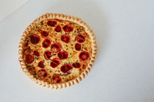 Free Close-up of a tomato quiche with visible herbs, perfect for food photography. Stock Photo