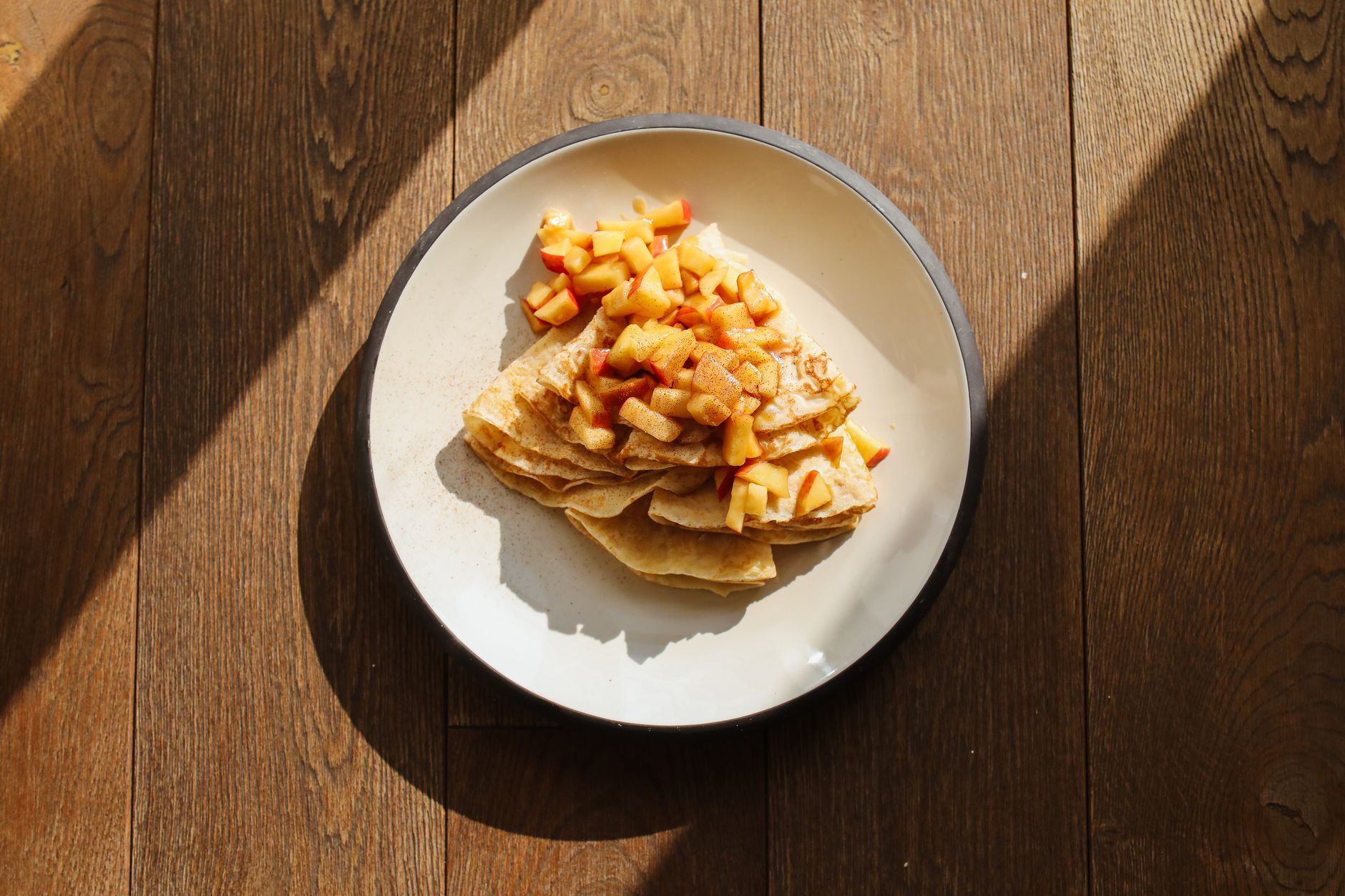 Stack of cinnamon oatmeal pancakes with honey apple compote