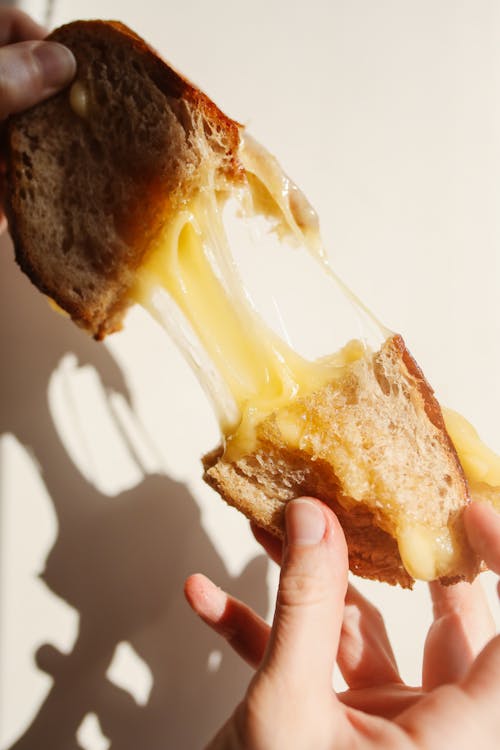 Close-up of a Person Holding a Cheese Toast 