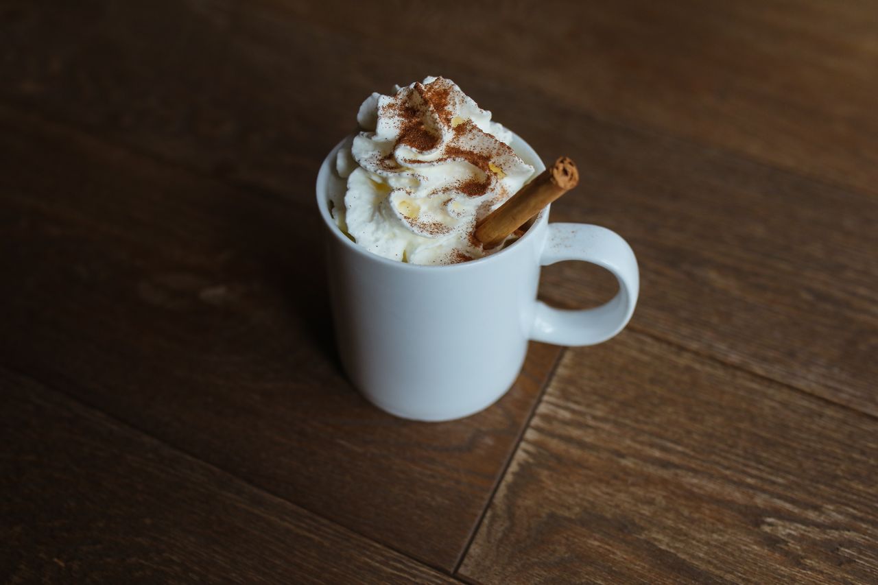 Cinnamon latte with whipped cream and a cinnamon stick