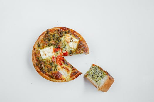 A tasty vegetarian pizza with fresh toppings on a white surface, captured in a top view.