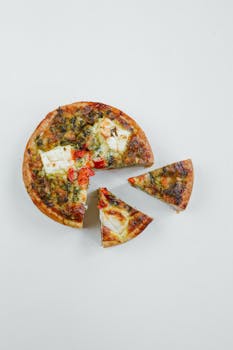 Delicious Italian pizza with distinct slices on a simple white background, perfect for food photography.