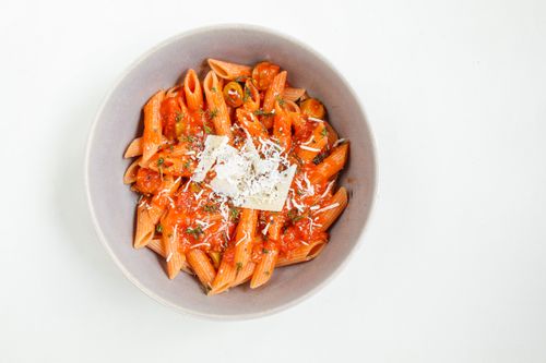 Free Top view of penne pasta with rich tomato sauce and grated cheese in a bowl. Stock Photo