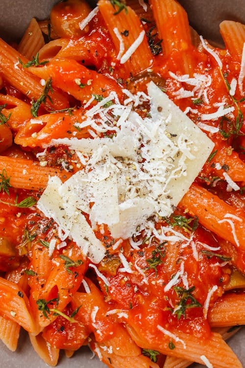 Free Delicious Penne Pasta Topped with Grated Cheese in Macro Shot Stock Photo