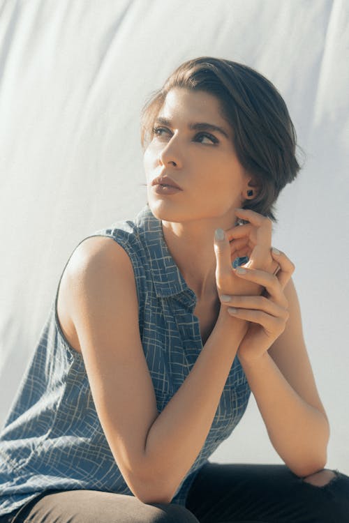 Young woman in blouse touching hands