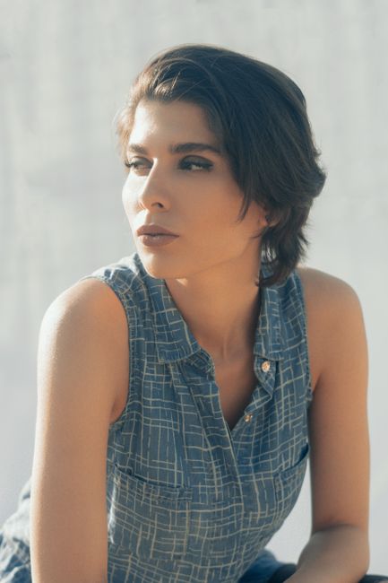 Pensive calm relaxed female with short hair looking away and pondering on gray background