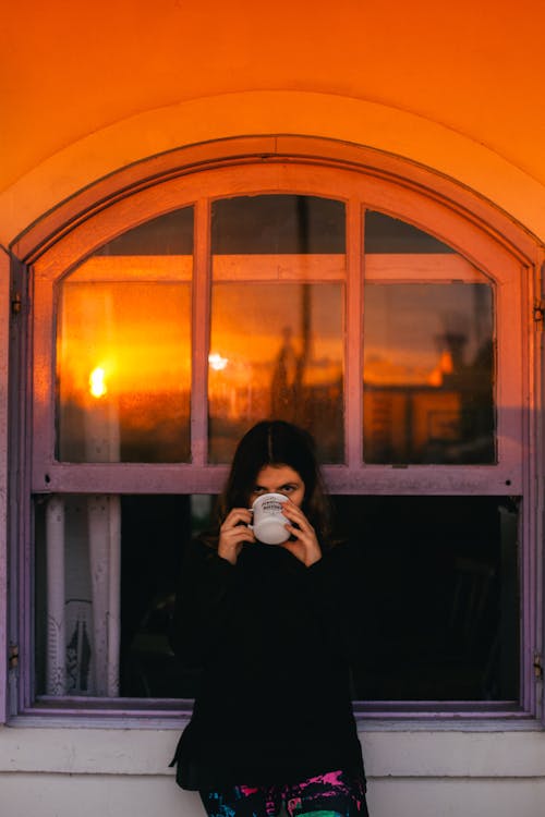 Free Cam Pencerenin Yanında Duran Siyah Uzun Kollu Gömlekli Kadın Stock Photo