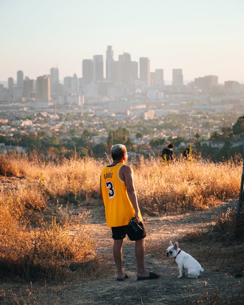 Man in Yellow and Black Nike Jersey Shirt and Black Shorts Standing on Brown Grass Field