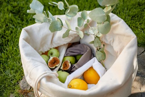Free Stylish canvas bag filled with fresh fruits: figs, lemons, and apples. Stock Photo