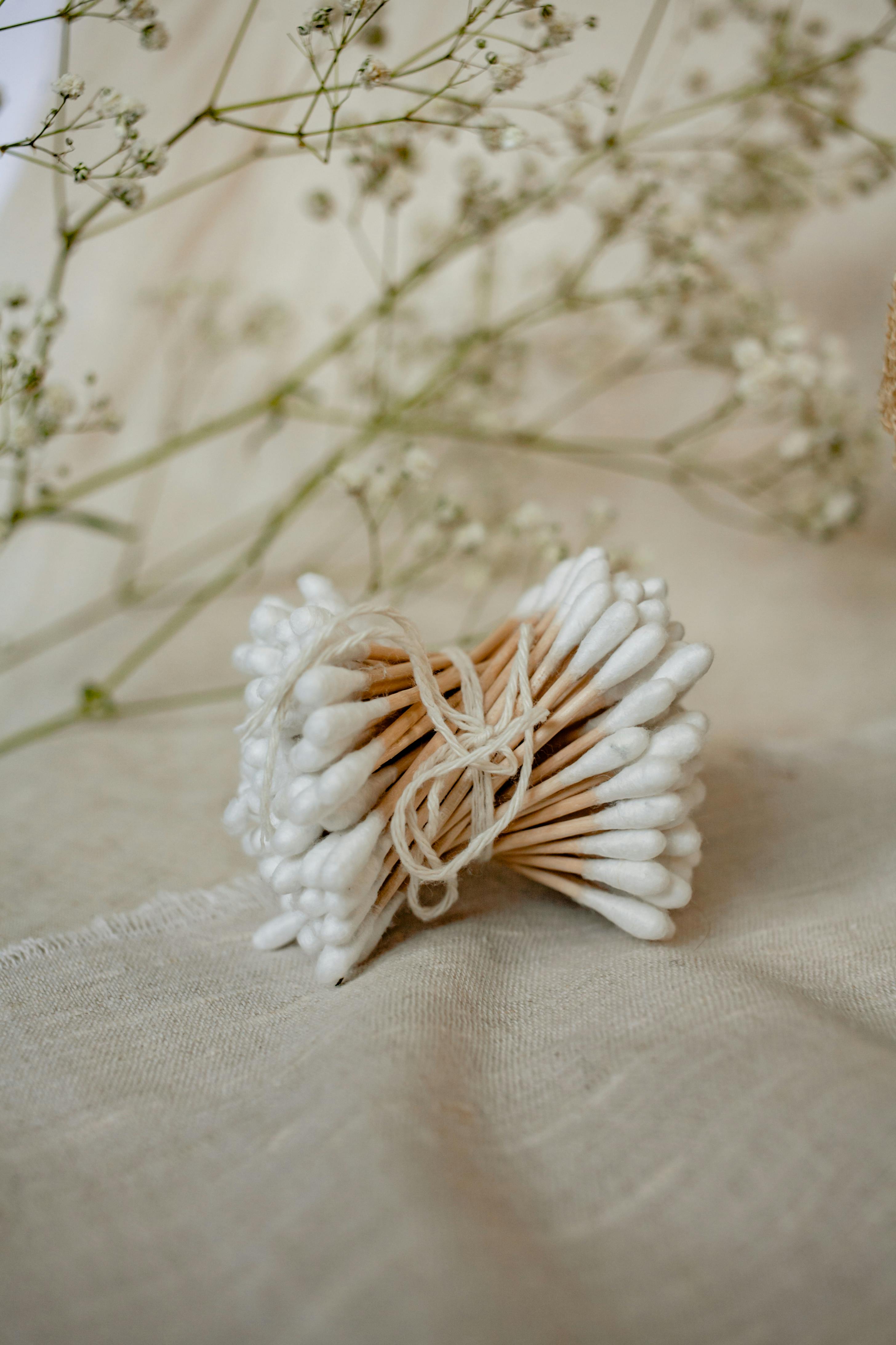 Aesthetic composition of cotton swabs with a soft floral background, perfect for wellness themes.