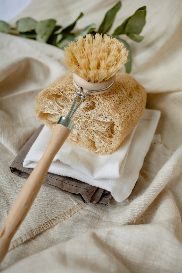 A Body Brush With Wooden Handle On Loofah Sponge