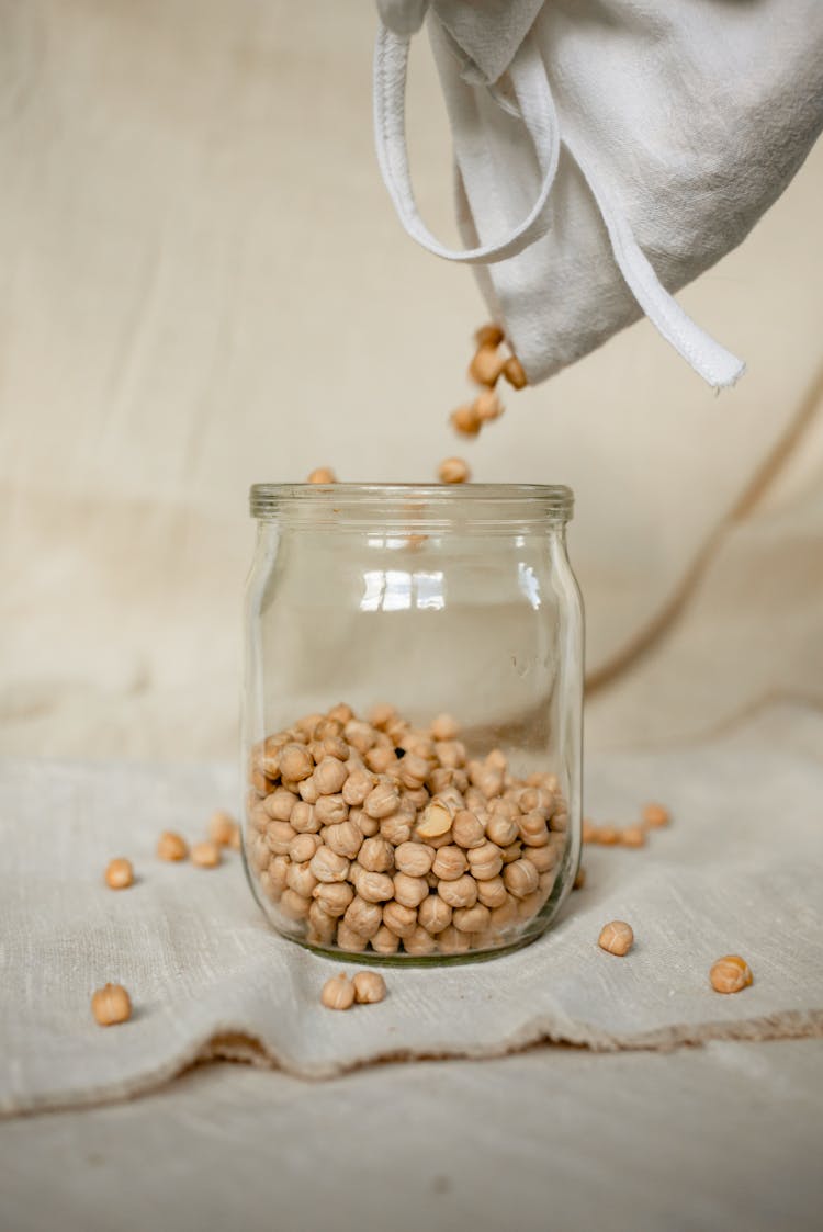 Pouring Dry Chickpeas From A Linen Eco Bag Into A Jar