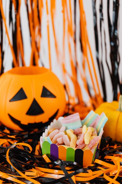 Free Colorful Halloween candy with pumpkins and streamers, perfect for a festive celebration. Stock Photo