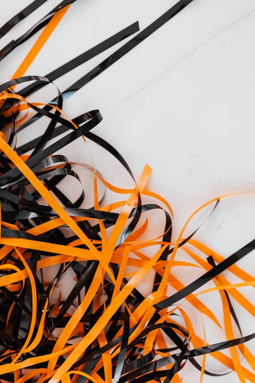 Free A Black and Orange Plastic Strips on White Surface Stock Photo