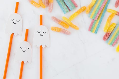 Orange Straws with Ghost Decorations and Colorful Jelly Candy 