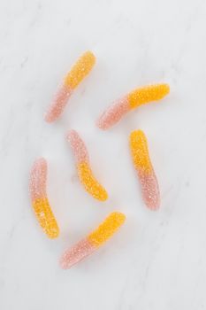 彩色糖衣蠕虫软糖在白色大理石背景上的特写