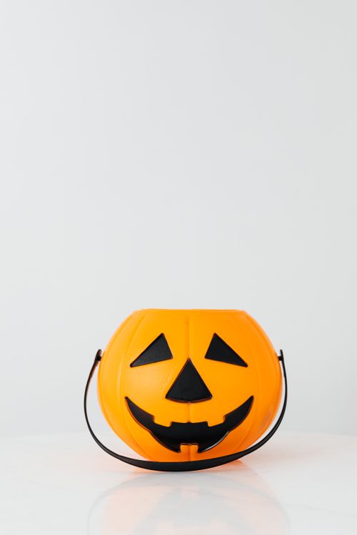 Free Colorful plastic pumpkin toy with a smiling face perfect for Halloween decor. Stock Photo