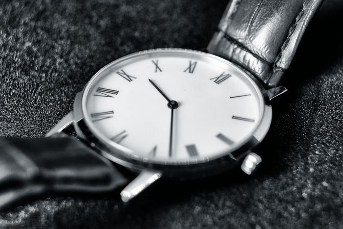 Monochrome dress watch with Roman numerals on dark fabric — photo by Mat Brown on Pexels