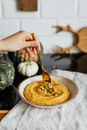 Person Holding Stainless Steel Spoon With Brown Pastry