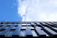 以蓝天为背景，低角度拍摄现代玻璃立面建筑，突显城市风貌