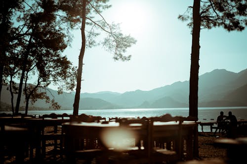 Silhouette of Tables and Chairs near the Lake