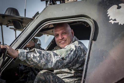 Free Man in Green and Black Camouflage Uniform Sitting Inside Car Stock Photo