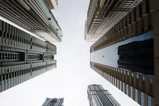 Dynamic low-angle shot of towering skyscrapers in a modern cityscape under a clear sky.