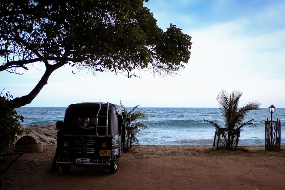 A tuk-tuk parked on a sandy beach in Sri Lanka overlooking the ocean A tuk-tuk parked on a sandy beach in Sri Lanka overlooking the ocean